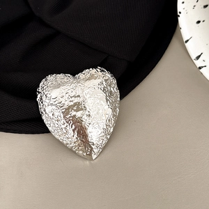 Detail shot of heart-shaped phone grip with silver crinkle foil metal texture