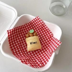 Macro detail of a creative kiwi fruit phone stand inside a fresh delivery box