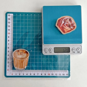 Detail shot of bread and coffee acrylic phone grips on an electronic scale for weight check