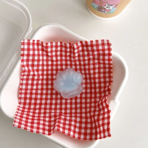 Close-up of light blue cat paw phone socket with heart detail on checkered napkin