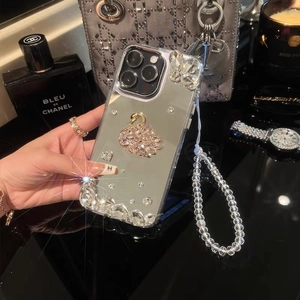 Close-up of silver mirror iPhone case with rhinestone swan and beaded wrist strap