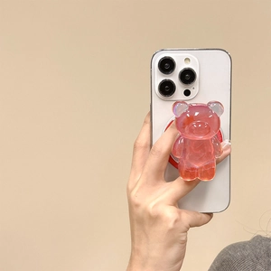 Détail d'un support de téléphone ours en résine rose 3D sur un smartphone blanc