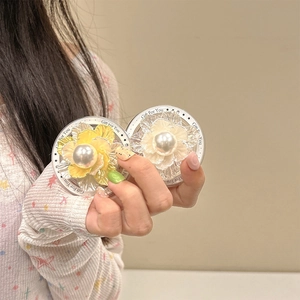 Détail du support de téléphone floral avec pétales nacrés et perle centrale