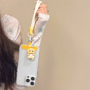 Détail de coque iPhone avec fente carte jaune, breloque chien et dragonne tressée à la main