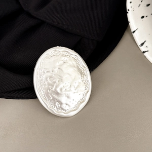 Detail shot of silver oval phone socket with vintage hammered lava texture and wave edge
