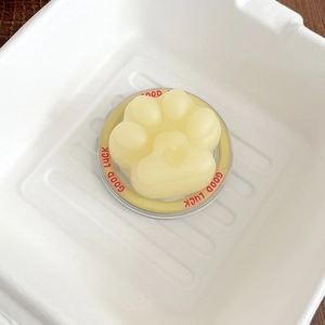 Detailed macro of a yellow cat paw shape holder with heart motif and Good Luck text