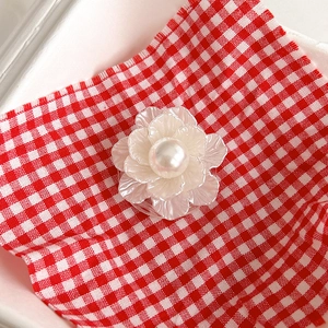 Macro shot of pearl flower cell phone socket with shimmering white petals and center bead