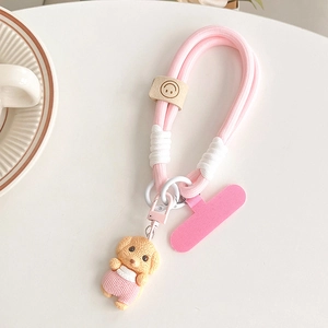 Détail du cordon de téléphone tressé rose avec pendentif chien et attache en cuir souriante