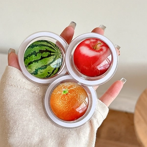 Detailed view of 3D fruit-shaped phone grips featuring watermelon, orange and apple designs