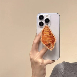 Close-up of realistic 3D croissant phone grip stand with chocolate drizzle detail
