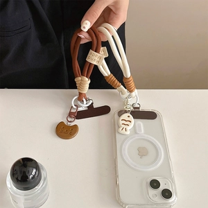Detail of hand made braided phone lanyards in brown and beige with cat and fish charms