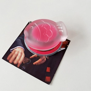 Détail du support MagSafe en forme de poisson rose avec inscription Good Luck