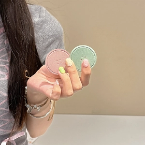 Detail of round leather phone sockets in pink and green with textured button design