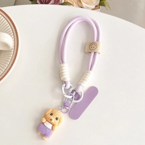 Détail d'un cordon de téléphone tressé violet avec pendentif ourson et charms en résine