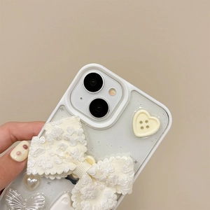 Detail of 3D embossed floral bow and metallic heart charm on cream white iPhone case