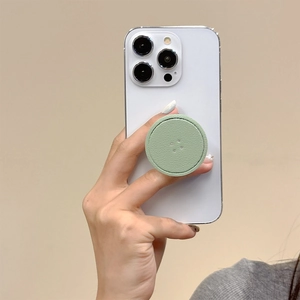 Detail of round green leather phone grip with premium lychee texture and fine stitching