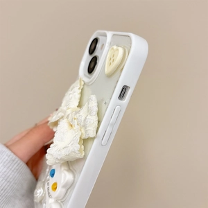 Close-up of 3D lace bow and cream-style heart decorations on a white iPhone case
