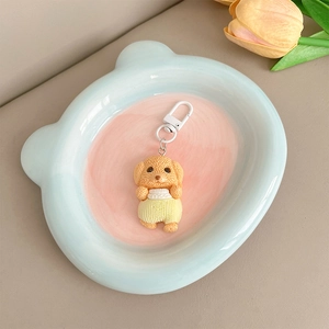 Détail du pendentif chien teddy en résine avec salopette jaune et fermoir en métal blanc