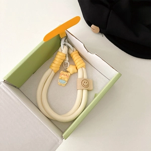 Detail of woven phone lanyard with cartoon bear and star pendants in a gift box
