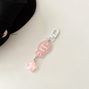 Macro detail of pink glitter resin fish and star charms with durable white metal clasp