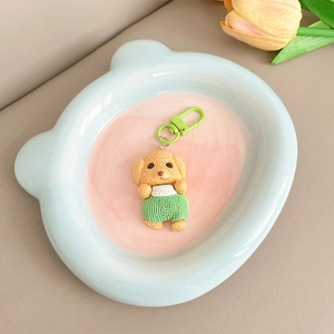 Vue détaillée d'un pendentif chien 3D mignon posé dans un plateau en céramique ours