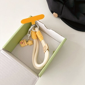 Detail of hand-woven phone lanyard with cute 3D cream bear and yellow star charms
