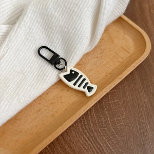 Close-up of a black and white fishbone charm with a sturdy metal lobster clasp