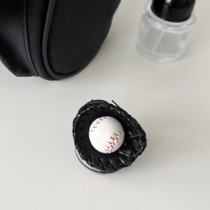Detail of baseball glove phone socket with miniature ball on neutral grey background