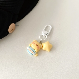 Detail of cartoon bear in blue coffee cup charm with a yellow star and white metal hook