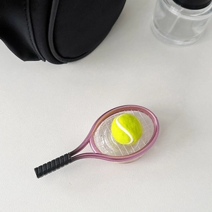 Detail showing a pink mini tennis racket and yellow ball as a creative phone grip stand