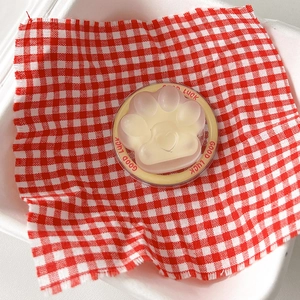 Detail view of a cat paw phone socket on red checkered fabric with Good Luck text