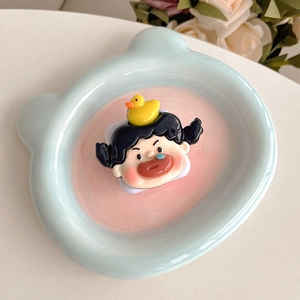Detail of cute cartoon girl phone grip with 3D yellow duck on a blue ceramic tray