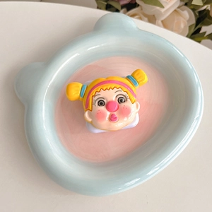 Detail of cute cartoon girl phone grip and mirror on a bear-shaped ceramic tray