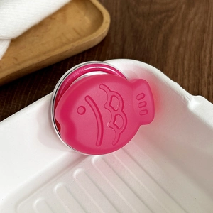 Détail du support de téléphone rose en forme de poisson avec écailles en relief rose