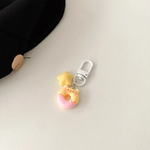 Detail of cartoon resin star and pink bear donut charm with white metal clasp
