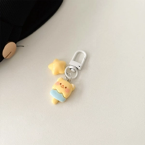 Detail of yellow bear popsicle charm and star pendant with white metal clasp