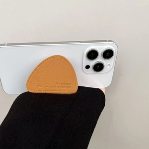 Detail of tan leather phone grip with lychee texture and fine stitching on white smartphone
