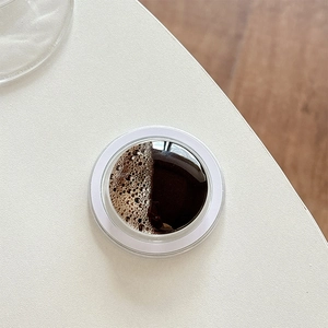 Detail view of round magnetic phone stand with dark liquid texture coffee bubble pattern