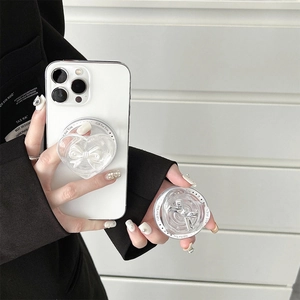 Detail of transparent heart phone grip with bow and 'Gift For You' text on white smartphone
