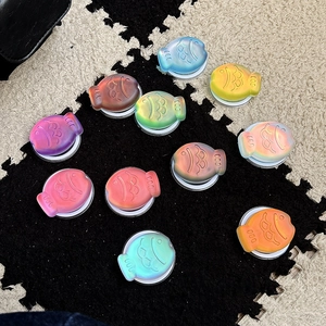 Colorful fish-shaped magnetic phone sockets with a matte gradient finish on a plush mat