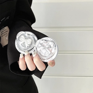 Detail of hand holding a transparent heart phone grip with 3D white bowknot inside