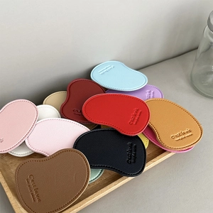 Close-up of mango-shaped leather phone grips with C'est la vie embossed text