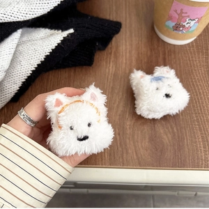 Cute white plush puppy and bear earphone cases with colorful hair clips on desk