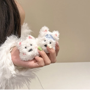 Close-up of cute white plush puppy phone sockets with a blue striped hat on hand