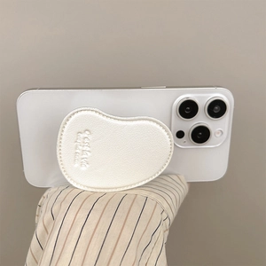 Close-up of pearl white leather heart phone grip with embossed c'est la vie text