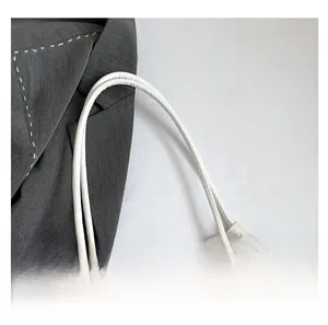 Detailed view of striped embroidery texture and reinforced white dual top handles on tote