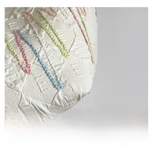 Macro detail of beige tote bag fabric with embossed letters and colorful chain embroidery