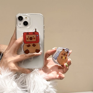 Cute cartoon capybara phone grip set with transparent acrylic case on warm background