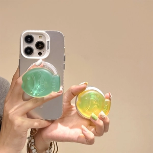 Detail of cute laser fish magnetic phone socket grip in translucent green silicone