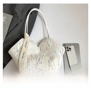Detail shot of white tote bag featuring quilted texture and rainbow drip embroidery